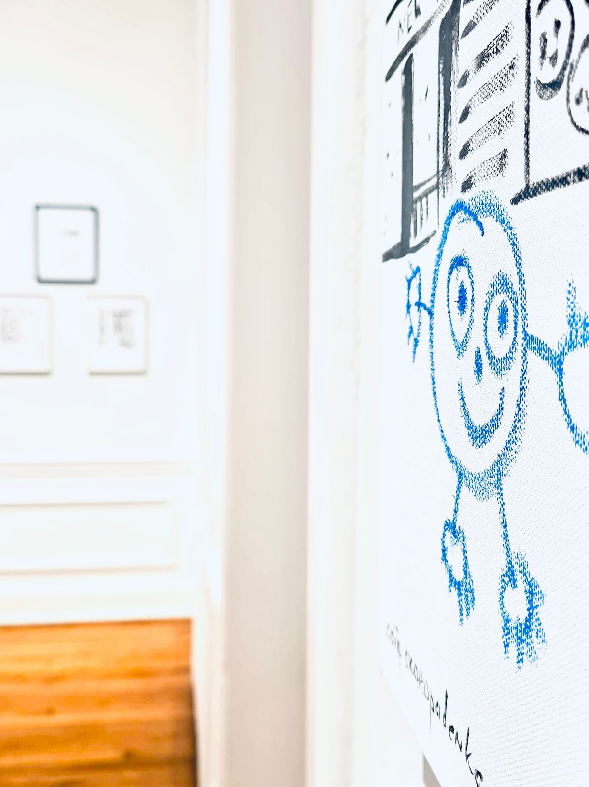Large Blue Boy graphic on a gallery wall seen through a doorway at the New York exhibition